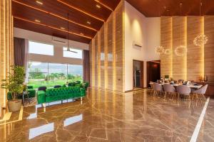 ロナバラにあるStayVista's Villa 107 at Canary Farms - Pure Veg with Huge Lawn, Pool and Home Theatreの緑のソファとテーブルが備わるロビー