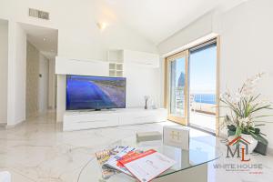 a living room with a large tv and a large window at Orchidea House by ML WHITE HOUSE in Genova