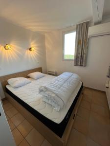 un letto grande in una stanza con una finestra di Appartement Les Restanques du Golfe de Saint-Tropez a Grimaud Altre 29 foto