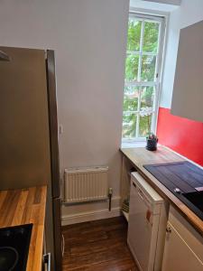 a kitchen with a refrigerator and a window at Flat in Hammersmith - Close to tube station in London