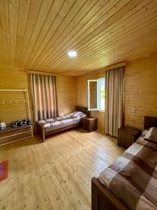 En eller flere senger på et rom på Ushba Cottages
