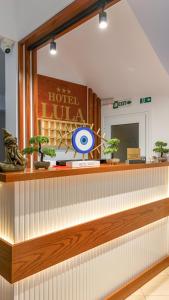 una hall di un hotel con un bancone della reception decorato con piante di Hotel Lula Ksamil a Ksamil