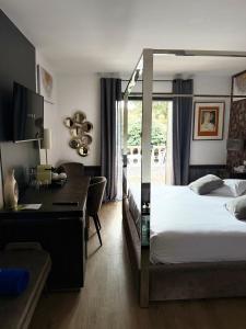 Una habitación de hotel con una cama y un escritorio y un escritorio. en La Villa Dune, Hôtel & Spa, en Saint-Tropez