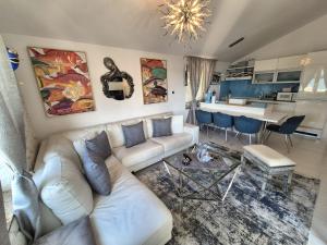 a living room with a white couch and a kitchen at Apartment Sonja in Klimno
