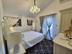 a bedroom with a white bed and a chandelier at Apartment Sonja in Klimno