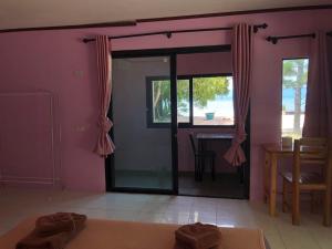 a room with pink walls and a table and a window at Nicha Resort Koh Phangan in Thong Sala