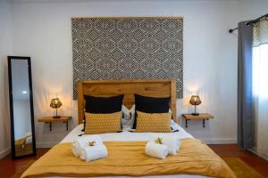 ポンタ・デルガダにあるGuestReady - Villa Islaのベッドルーム1室(大型ベッド1台、黄色い枕付)
