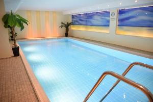 ein großer Swimmingpool in einem Hotelzimmer in der Unterkunft Freundliches 2-Zimmer-Appartement mit Kieferneinrichtung und einem Balkon. in Westerland