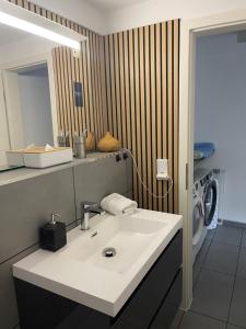a bathroom with a sink and a washing machine at Ostsee Ferienwohnung Möwengasse in Travemünde +15 photos
