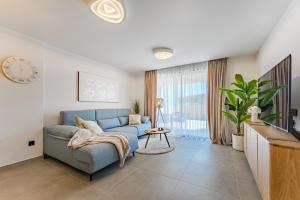 a living room with a blue couch and a clock at Oceanfront Oasis - Stunning beach view apartment in El Médano