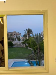 a view of a swimming pool from a window at قصر الأحلام فيلا أول سكن بمسبح خاص ومساحة 2000 متر in El Alamein