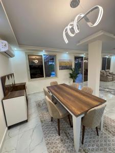 a dining room with a wooden table and chairs at قصر الأحلام فيلا أول سكن بمسبح خاص ومساحة 2000 متر in El Alamein