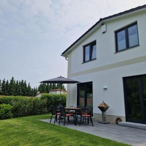 a patio with a table and chairs and an umbrella at Ferienhaus Marie in Wittenbeck