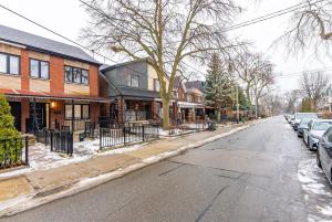 een straat met huizen en auto's op straat bij 3BR Home in Trinity Bellwoods - 2 Parking Spots in Toronto