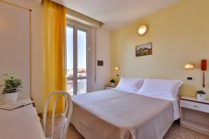 a small bedroom with a bed and a window at Hotel Paola Garden in Rimini