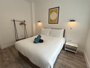 - une chambre dotée d'un grand lit blanc avec un oreiller bleu dans l'établissement Luxury 2 bedroom 2 bathroom All ground floor centrally located - 1 Queen Street - Ashbrook Serviced Apartments, à Abingdon 7 autres photos