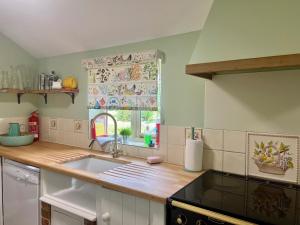 a kitchen with a sink and a window at Locks Lane Cottage in Geldeston +24 photos