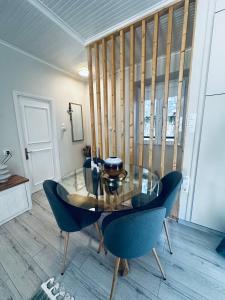 een eetkamer met een glazen tafel en blauwe stoelen bij G&A House in Gaios in Gaios