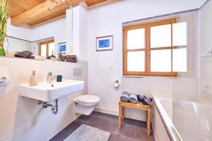 a bathroom with a sink and a toilet and a tub at Mountain Safari Garmisch - Spacious, scenic and steps from adventure in Garmisch-Partenkirchen +33 photos