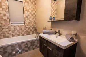 a bathroom with a sink and a bath tub at Bugibba - Central Luxury Seafront, only for family in St. Paul's Bay +21 photos