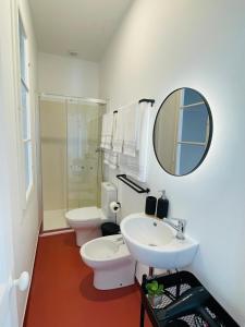 a bathroom with a sink and a toilet and a mirror at Casa da Arquitectura - Texturas in Angra do Heroísmo +37 photos