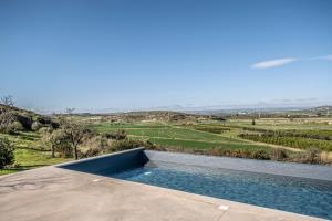 a swimming pool on the roof of a house at Tenuta le Menadi in Noto