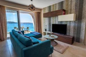 a living room with a blue couch and a television at Bugibba - Central Luxury Seafront, only for family in St. Paul's Bay