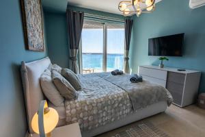 a bedroom with a bed with a view of the ocean at Bugibba - Central Luxury Seafront, only for family in St. Paul's Bay