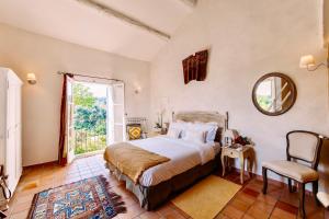 a bedroom with a bed and a mirror and a window at Bastide Saint-Didier in Saint-Didier