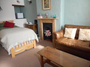 a living room with a bed and a couch at Glascoed Farmhouse in Carmarthen
