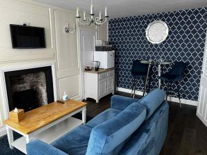 a living room with a blue couch and a table at The Little Angel in Whitby