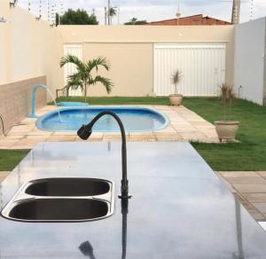 a kitchen sink in a yard with a pool at RR Deck Betolandia in Juazeiro do Norte +4 photos
