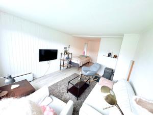 a living room with a white couch and a bed at Cozy apartment close to nature in Tromsø