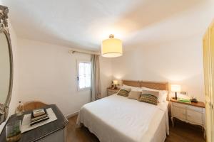 a bedroom with a white bed and a mirror at Villa Bianca in Villasimius +58 photos