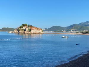 a large body of water with a house on an island at Apartments Lungo Mare in Sveti Stefan