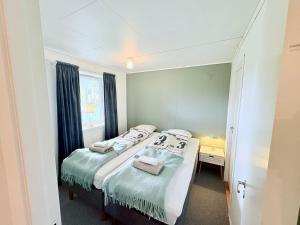 a small bedroom with two beds and a window at Cozy apartment close to nature in Tromsø