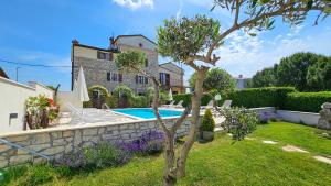 a garden with a swimming pool and a house at Olimpia 3 in Novigrad Istria