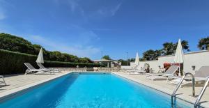 a swimming pool with chairs and umbrellas next to a building at Olimpia 3 in Novigrad Istria