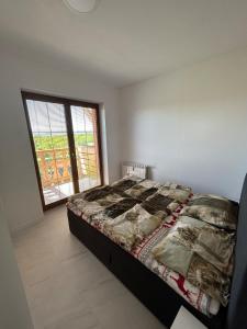 une chambre avec un lit et une grande fenêtre dans l'établissement Tatragolf Mountain Resort Apartment, à Veľká Lomnica 11 autres photos