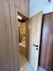 La salle de bains est pourvue d'une porte, d'une baignoire et de toilettes. dans l'établissement Tatragolf Mountain Resort Apartment, à Veľká Lomnica