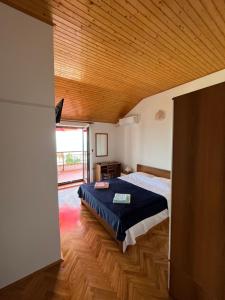 a bedroom with a bed and a wooden ceiling at View point rooms in Matulji