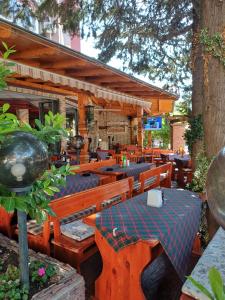 a restaurant with wooden benches and tables and trees at Admiral Plaza 35 -studio-Sunny Beach in Sunny Beach