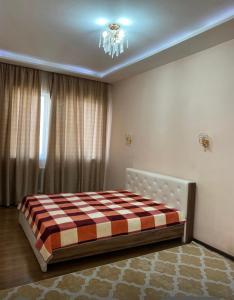 a bedroom with a bed with a checkered blanket at Жануя in Zhezdi