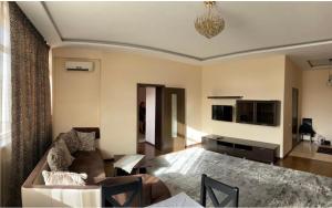 a living room with a couch and a tv at Жануя in Zhezdi