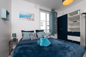 een slaapkamer met een blauw bed en een raam bij Santorin Îlot de Merville - Centre in Lorient