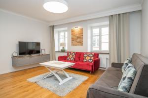un salon avec un canapé rouge et une télévision dans l'établissement Twin apartments 3 Bedr by Reside Baltic, à Vilnius