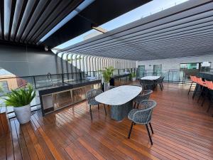 a room with a table and chairs on a deck at Setai à beira-mar com rooftop incrível in João Pessoa
