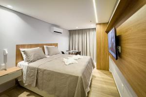 a hotel room with a bed with a towel on it at Setai à beira-mar com rooftop incrível in João Pessoa +144 photos
