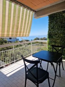 un tavolo e sedie su un patio con vista sull'oceano di Akis, terrazza sul mare ad Aci Castello