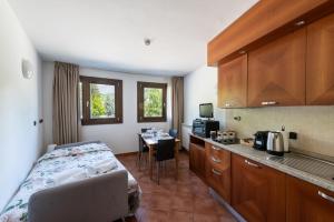 a room with a bed and a kitchen with a table at Sogno di Montagna sulle piste da Sci in Bardonecchia